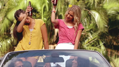 Group-of-friends-drinking-beer-in-a-convertible-car