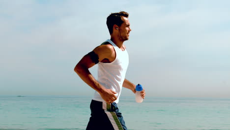 Athletic-man-jogging-across-the-beach