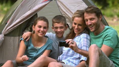 Cheerful-family-looking-at-photo-on-camera-
