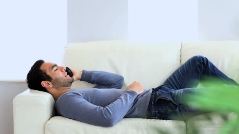 Man-having-a-phone-conversation-on-the-couch