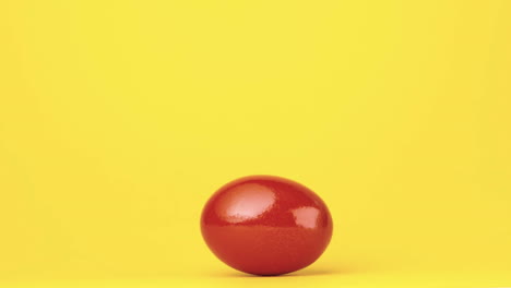 Huevo-Rojo-Girando-Sobre-Fondo-Amarillo