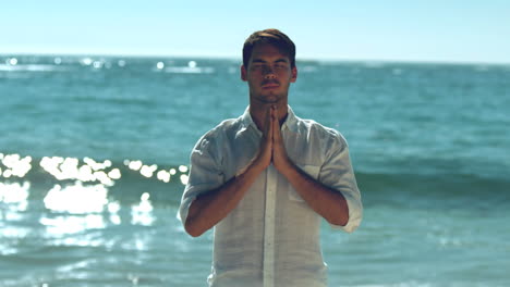 Handsome-man-practicing-yoga-on-the-beach