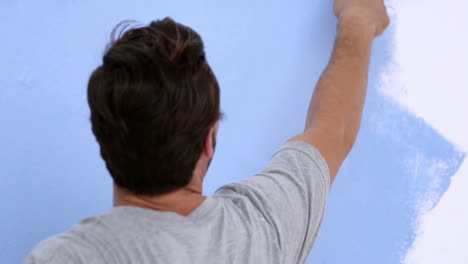 Man-painting-a-wall-in-blue