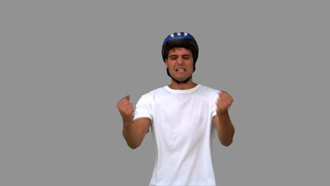 Man-wearing-a-helmet-holding-his-head-grey-screen