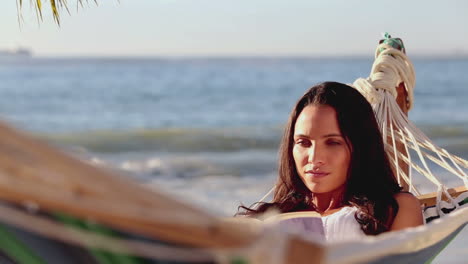 Brunette-woman-reading-a-book-on-a-hammock