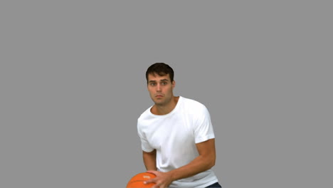 Gutaussehender-Mann-Fängt-Und-Wirft-Einen-Basketball-Auf-Grauem-Bildschirm