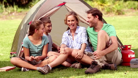 Family-sitting-in-front-of-their-tent-spending-time-together