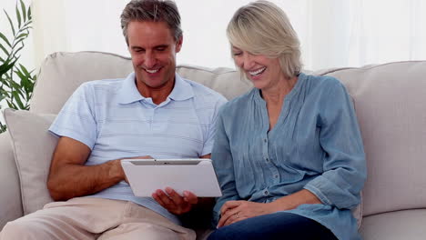 Mature-couple-using-a-tablet-pc-on-the-couch