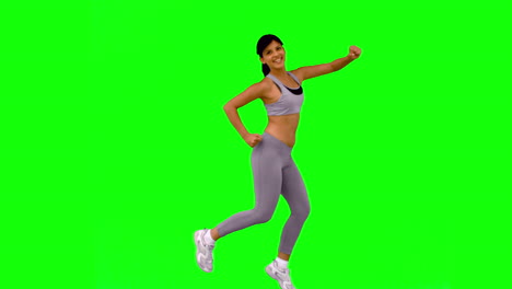 Athletic-woman-jumping-and-posing-on-green-screen