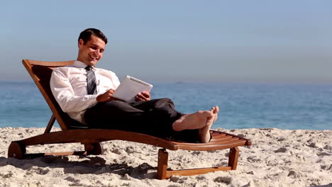 Unstressed-businessman-relaxing-with-a-tablet-pc-
