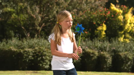 Niña-Soplando-Un-Molinete-En-Su-Jardín.-