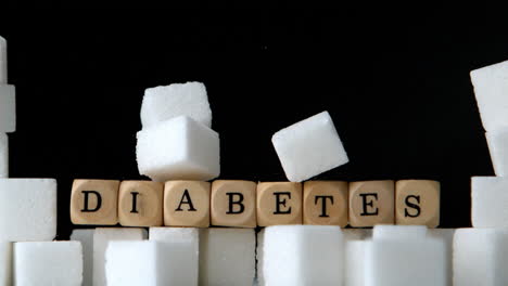 Zuckerwürfel-Und-Würfel,-Die-Diabetes-Buchstabieren,-Fallen-Auf-Schwarzem-Hintergrund-Herunter