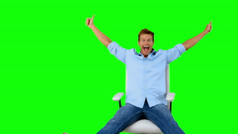 Man-on-swivel-chair-giving-thumbs-up-on-green-screen