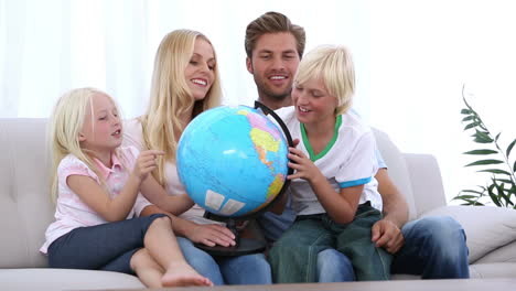 Family-looking-at-globe-together