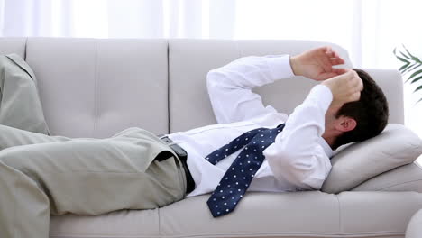 Businessman-crashing-down-onto-sofa