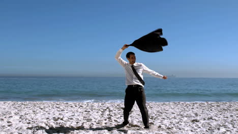 Businessman-undressing-and-throwing-his-jacket-on-the-beach