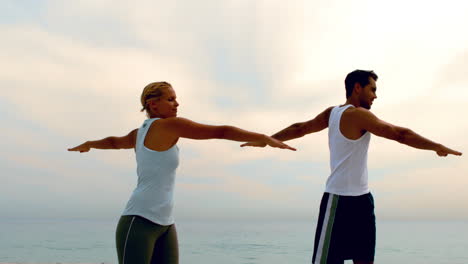 Hombre-Y-Mujer-Haciendo-Pilates-En-La-Playa