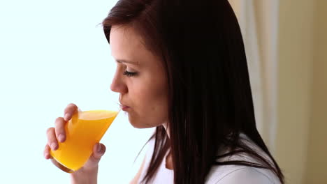 Mujer-Joven-Bebiendo-Jugo-De-Naranja