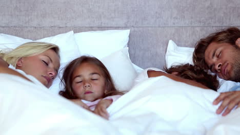 Family-sleeping-together-in-bed