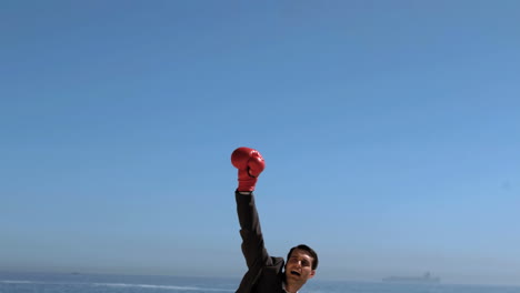 Attractive-businessman-jumping-with-red-boxing-gloves