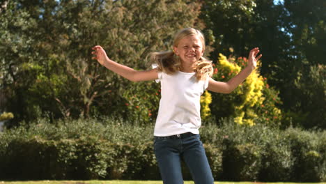 Cheerful-little-girl-jumping-in-her-garden