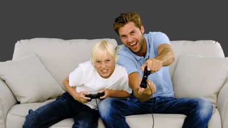 Vater-Und-Sohn-Spielen-Videospiele-Auf-Dem-Sofa-Auf-Grauem-Hintergrund