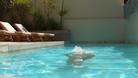 Frau-Taucht-In-Den-Swimmingpool-Ein