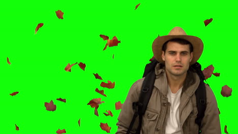 Man-with-a-hat-walking-under-leaves-falling-on-green-screen