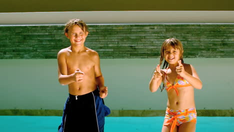Siblings-dancing-together-in-front-of-the-swimming-pool