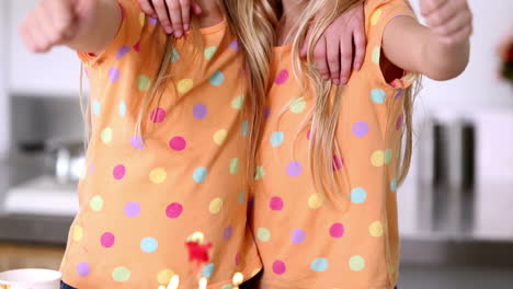Twin-sisters-with-thumbs-up-at-birthday-party