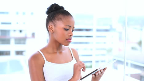 Thoughtful-natural-model-using-her-tablet-computer