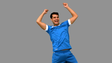 Happy-football-player-gesturing-after-a-goal-on-grey-screen