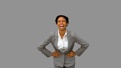Attractive-businesswoman-laughing-on-grey-screen