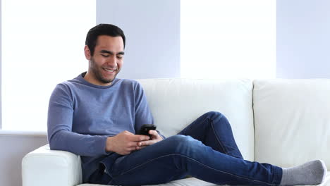 Man-text-messaging-on-the-couch