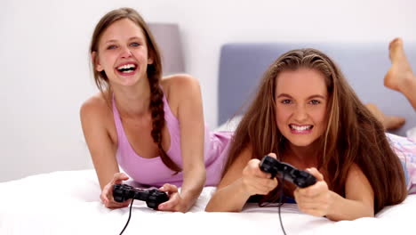 Excited-girls-playing-video-games-on-bed