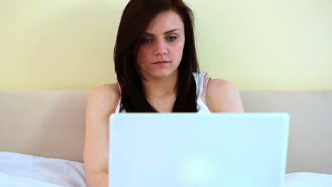 Woman-using-her-laptop-in-her-bed