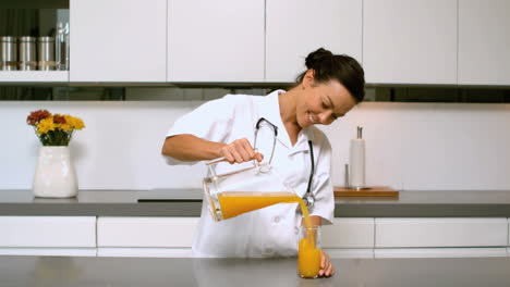 Home-nurse-pouring-glass-of-orange-juice-in-kitchen