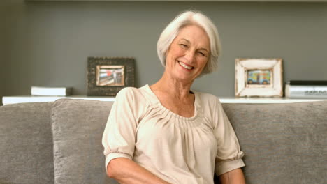 Happy-retired-woman-smiling-on-couch