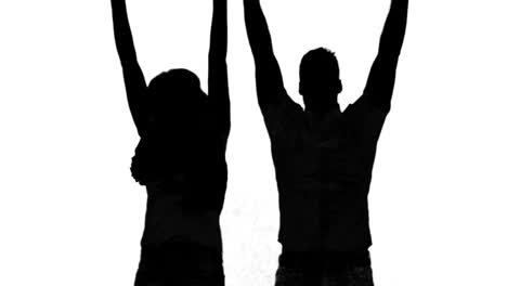 Silhouette-of-couple-jumping-and-raising-arms-on-white-background