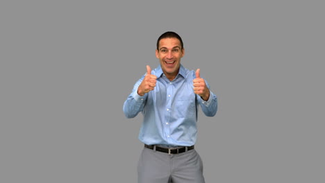 Cheerful-businessman-giving-thumbs-up-on-grey-screen