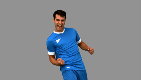 Cheerful-football-player-gesturing-on-grey-screen-
