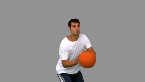 Handsome-man-playing-with-a-basketball-on-grey-screen