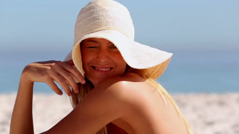 Woman-wearing-a-straw-hat-and-sitting-on-the-beach-