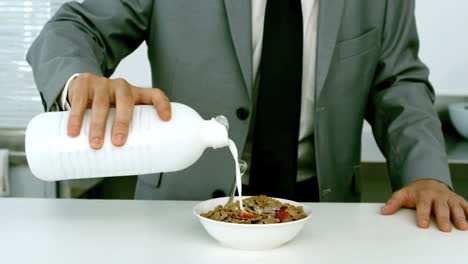 Well-dressed-businessman-pouring-milk-into-his-cereals