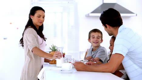 Mother-pouring-milk-at-family-breakfast