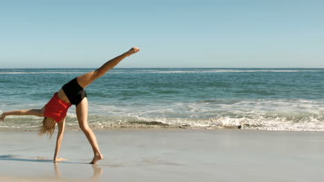 Mujer-Haciendo-Una-Voltereta-En-La-Playa