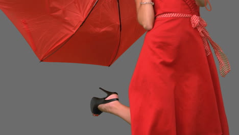 Woman-in-high-heels-holding-a-broken-umbrella-on-grey-screen