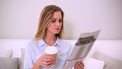 Woman-reading-newspaper-and-drinking-coffee