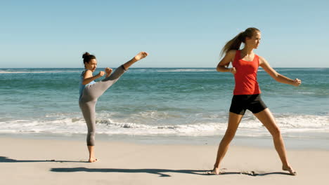 Two-women-doing-martial-arts-on-the-beach
