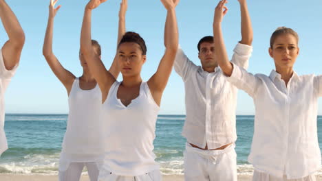 Grupo-De-Personas-Practicando-Yoga-En-La-Playa